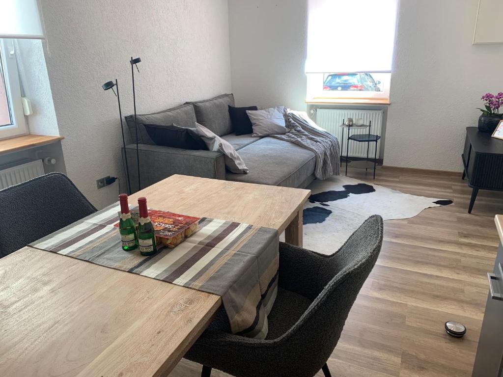 uma sala de estar com uma mesa e um sofá em Nibelungen Boardinghouse 1 Zimmer Apartment em Lindenfels