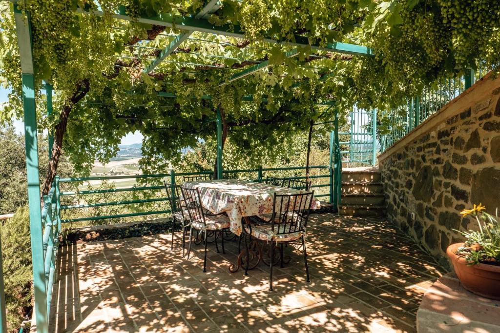 MonteneroにあるLittle Val D'Orciaのパーゴラの下に座るテーブルと椅子