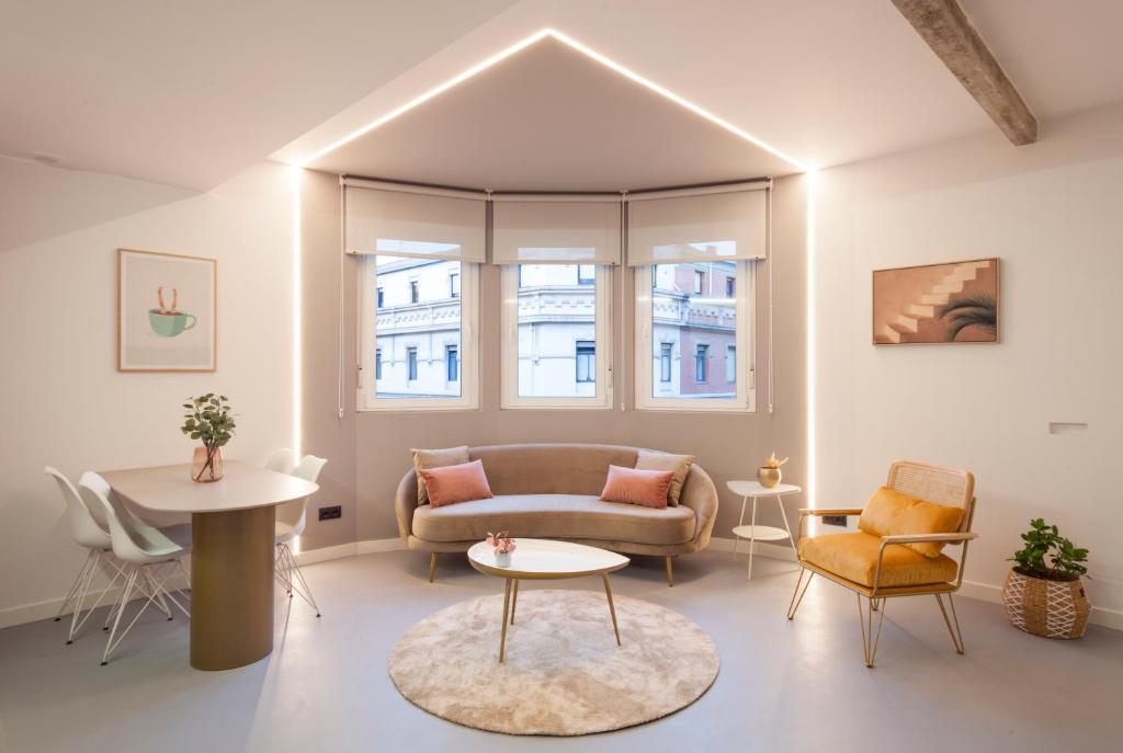 a living room with a couch and chairs and a table at Bilbao Centric Apartments in Bilbao