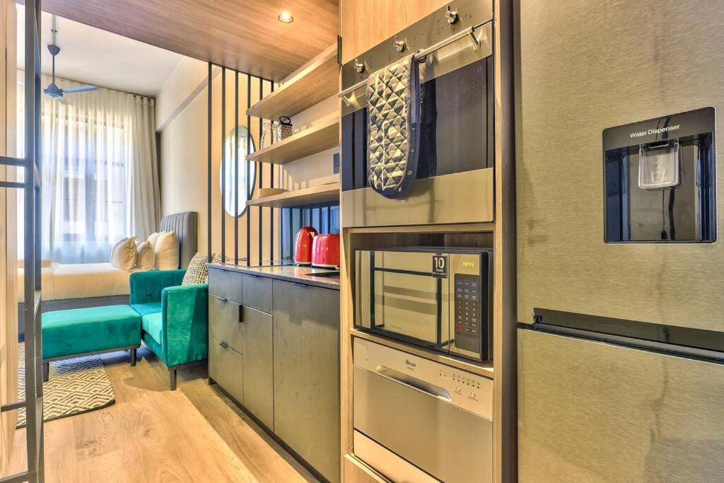 eine Küche mit einem Herd und einer Mikrowelle in der Unterkunft Luxurious Designer Gem located at The Harri in Kapstadt
