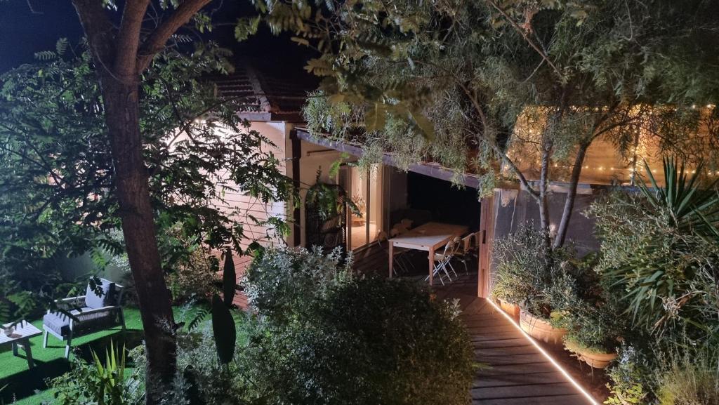 uma casa com um jardim à noite com uma mesa e cadeiras em Olives em Arad