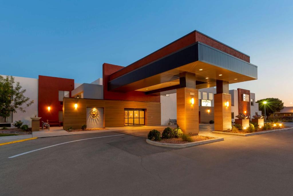 a large office building with a parking lot at Best Western Pecos Inn in Artesia