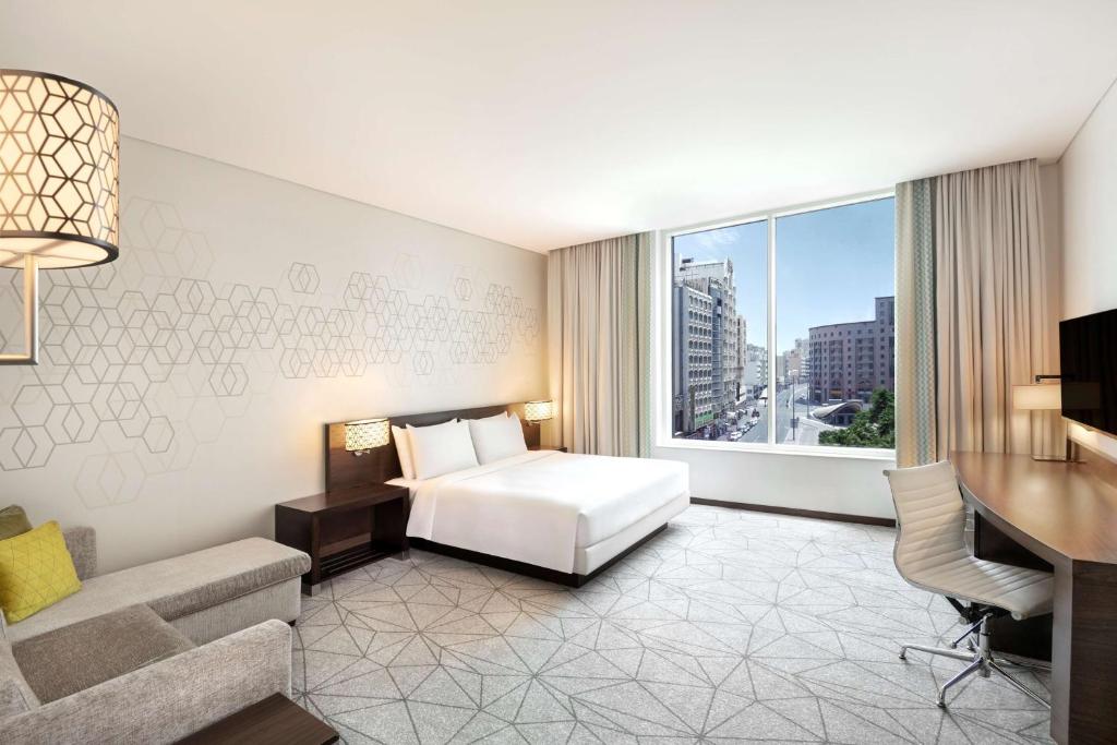 - une chambre avec un lit, un bureau et une fenêtre dans l'établissement Hyatt Place Dubai Baniyas Square, à Dubaï