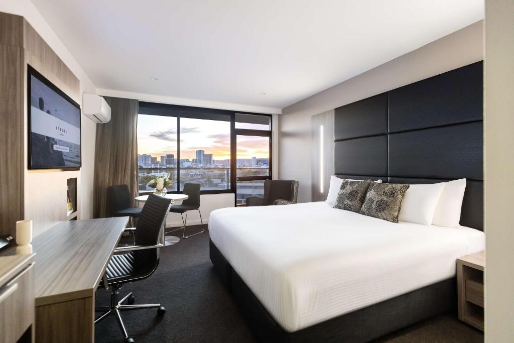 a hotel room with a bed and a desk at Rydges South Park Adelaide in Adelaide