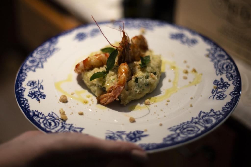 a person holding a plate with a piece of food at Hotel Edelweiss in Limone Piemonte