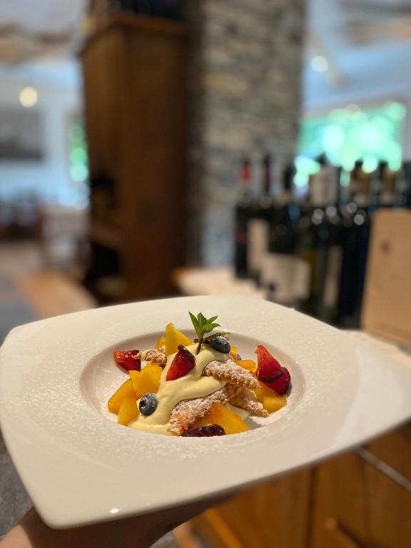 a plate of food with fruit on a table at Hotel Edelweiss in Limone Piemonte
