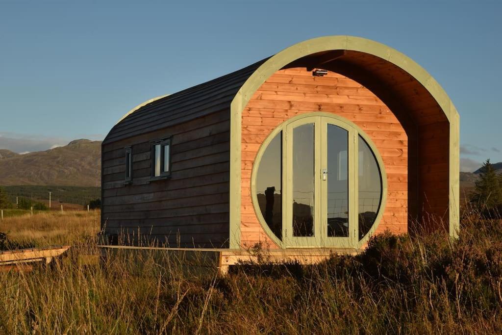 una piccola casa con una grande finestra in un campo di The Hobbit House on the Isle of Skye a Breakish