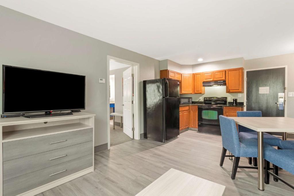 a kitchen and dining room with a television and a table at Best Western Plus Magnolia Inn & Suites in Cleveland
