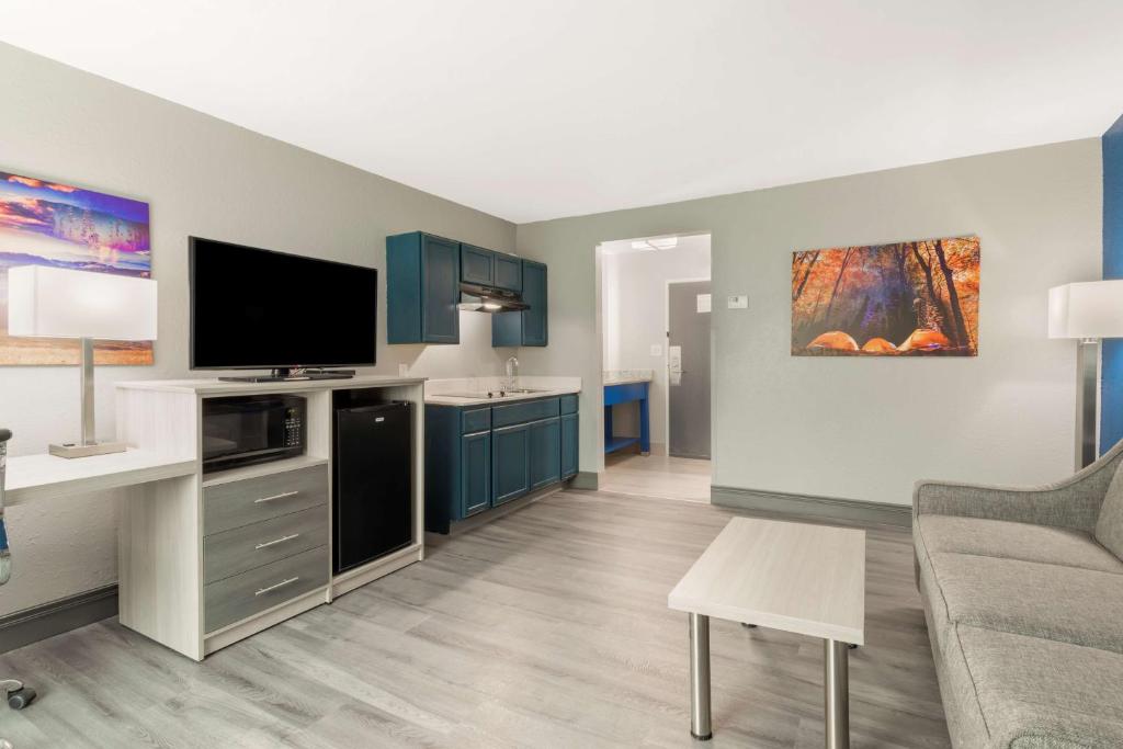 a living room with blue cabinets and a flat screen tv at Best Western Plus Magnolia Inn & Suites in Cleveland