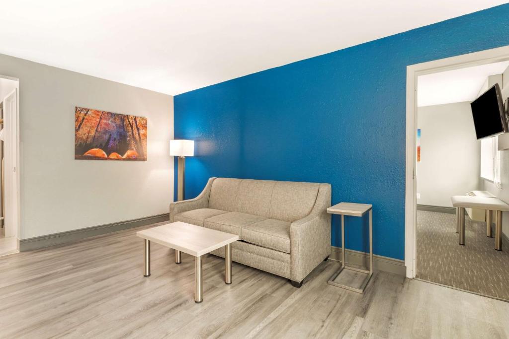 a living room with a couch and a blue wall at Best Western Plus Magnolia Inn & Suites in Cleveland