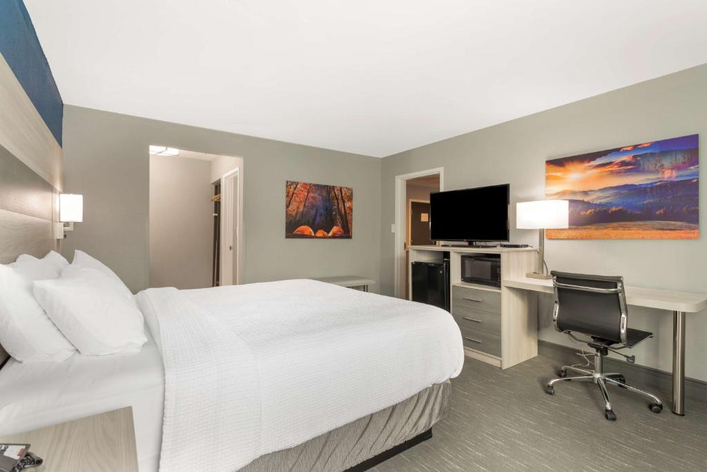 a hotel room with a bed and a desk and a computer at Best Western Plus Magnolia Inn & Suites in Cleveland