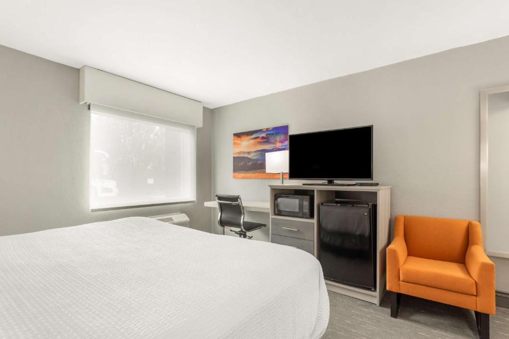 a hotel room with a bed and a flat screen tv at Best Western Plus Magnolia Inn & Suites in Cleveland