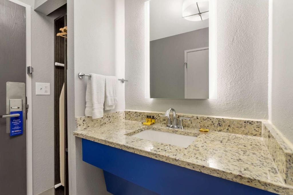 a bathroom with a sink and a mirror at Best Western Plus Magnolia Inn & Suites in Cleveland
