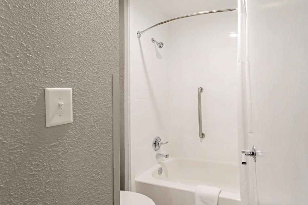 a white bathroom with a shower and a toilet at Best Western Plus Magnolia Inn & Suites in Cleveland