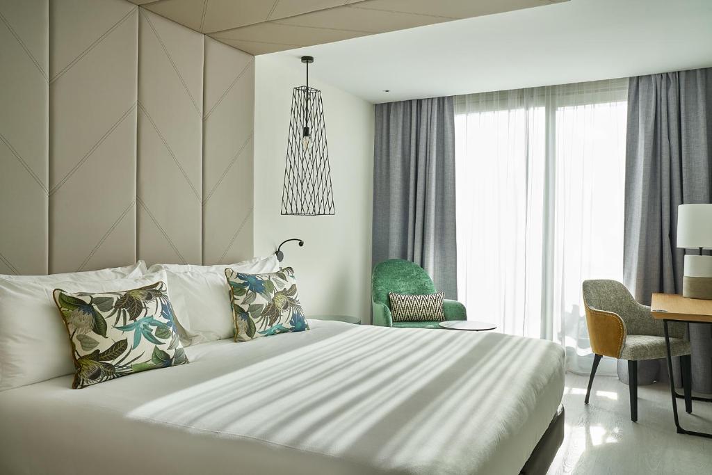 1 dormitorio con 1 cama, mesa y sillas en Vincci Larios Diez, en Málaga