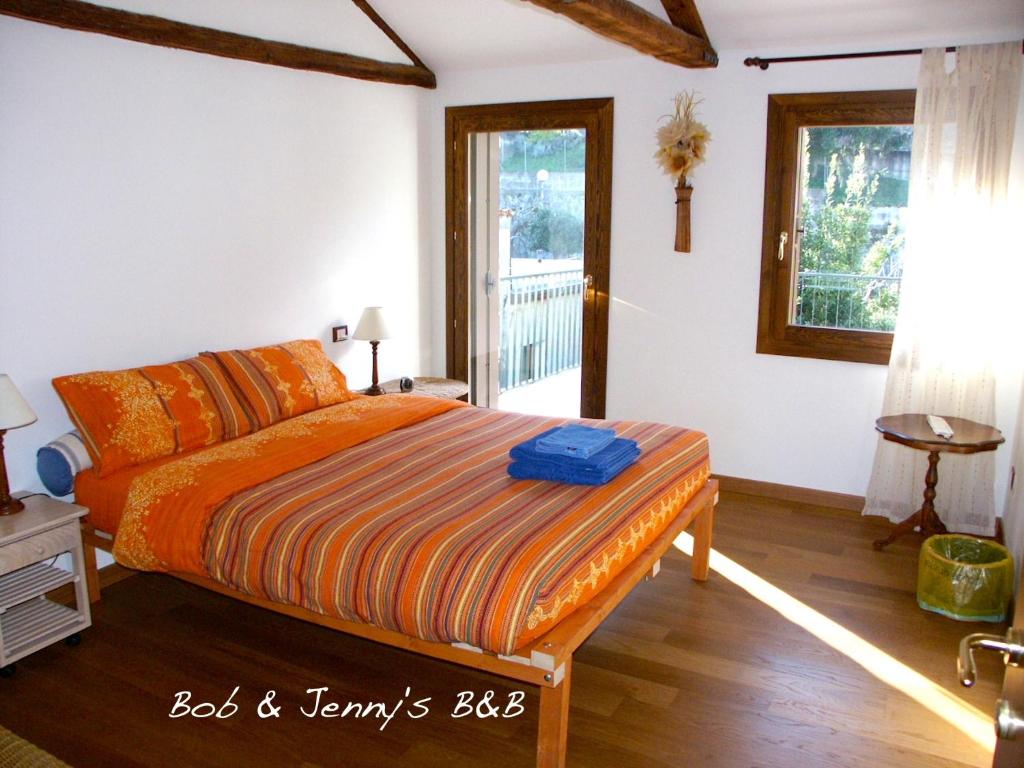 ヴィチェンツァにあるボブ アンド ジェニーズ B＆Bのベッドルーム1室(オレンジ色の掛け布団付きのベッド1台付)