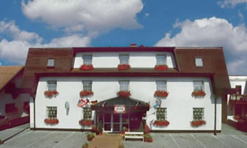 a large white building with flowers on the front at Hotel Pelikan in Mariánské Lázně