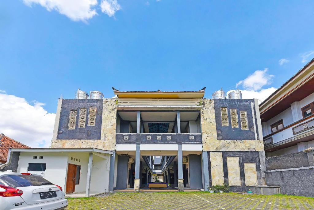 an old building with a car parked in front of it at Super OYO 91495 Hotel Indah Residence in Denpasar