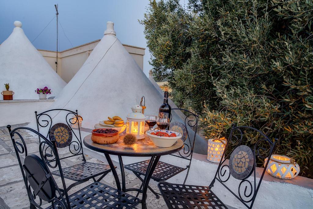 una mesa y sillas con comida y botellas de vino en Il Trulletto en Montalbano