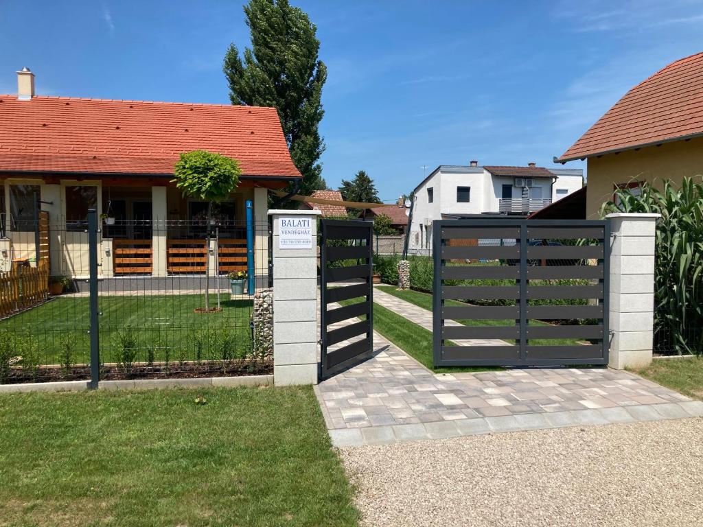 a black gate in front of a house at Balati Vendégház in Balatonmáriafürdő