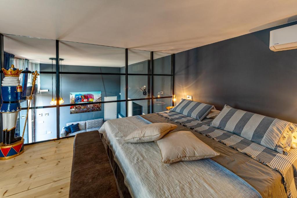 a bedroom with a large bed with glass walls at 147MqSuite in Santarcangelo di Romagna