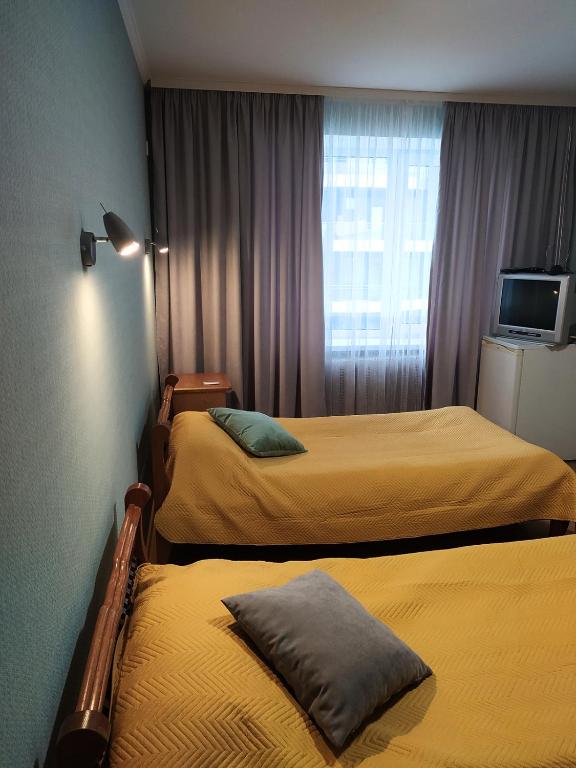 a hotel room with two beds and a television at Hotel Trias in Kyiv
