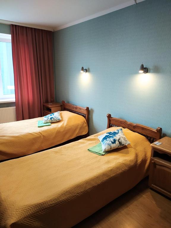 a hotel room with two beds and a window at Hotel Trias in Kyiv