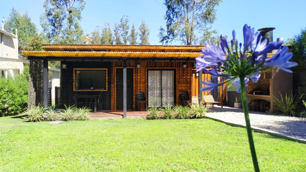 una pequeña casa con una flor en el patio en Casa de Playa en el Bosque en Mar del Plata