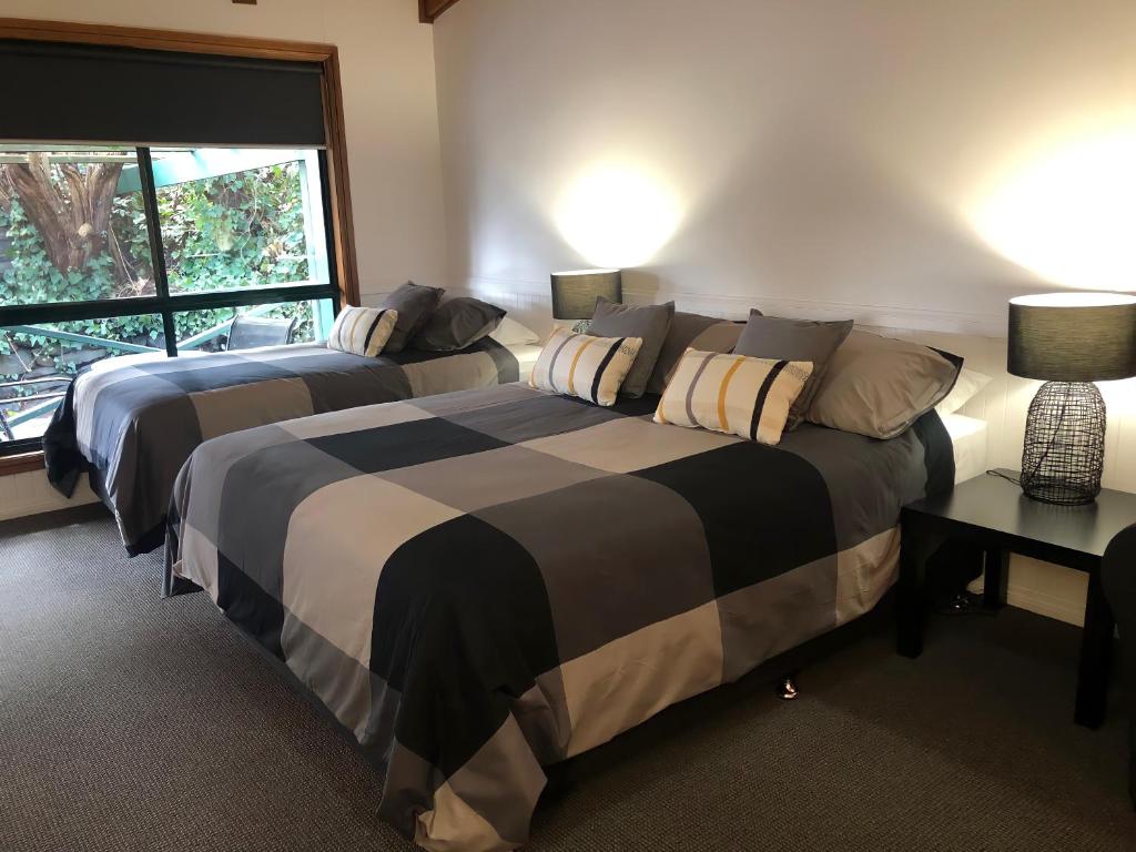 um quarto com 2 camas e uma janela em Black Range Lodge em Tumbarumba