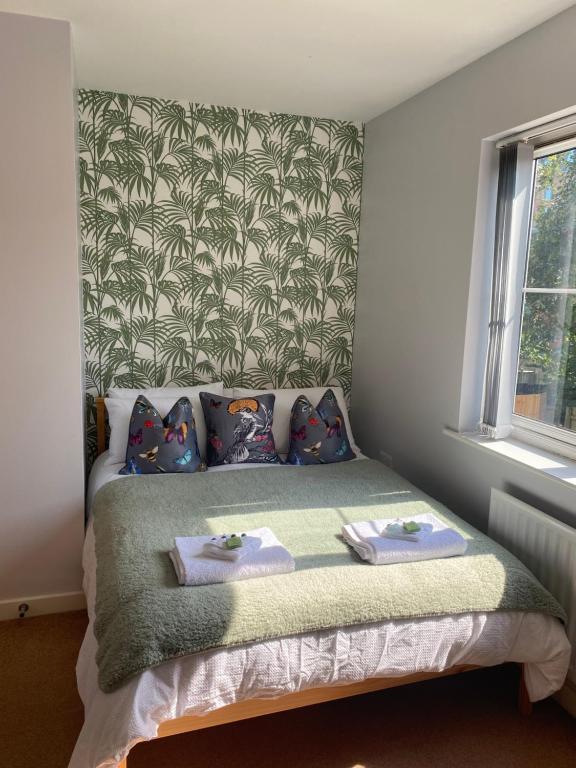 a bedroom with a bed with towels on it at Coventry City Centre townhouse with private parking in Coventry