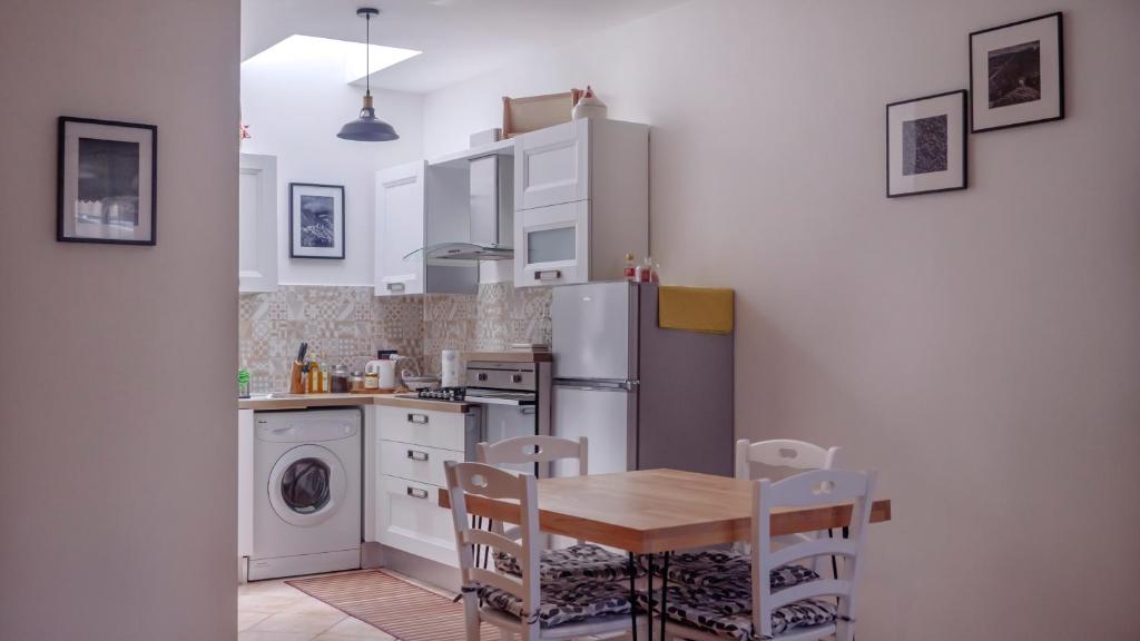 a kitchen with a table and a refrigerator at Alloggio del Vicolo - Le Vecchie Vasche in Coppito