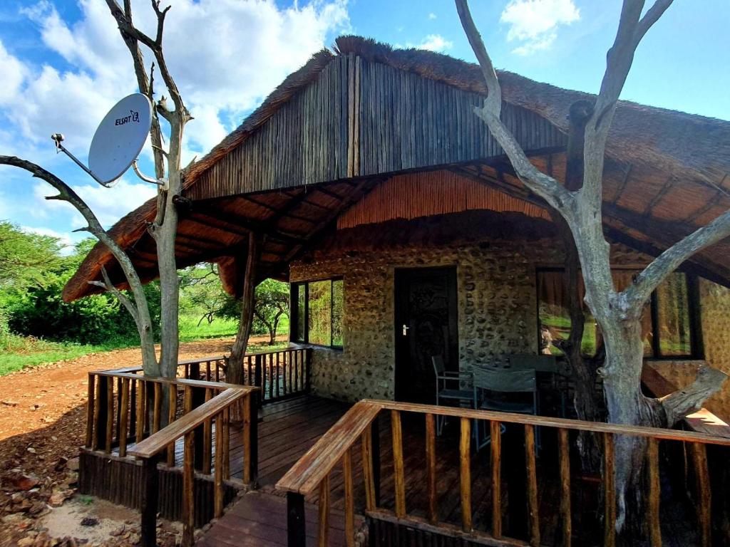 ein Haus mit einer Holzterrasse und einer Terrasse in der Unterkunft KaMsholo Bushveld Safaris 