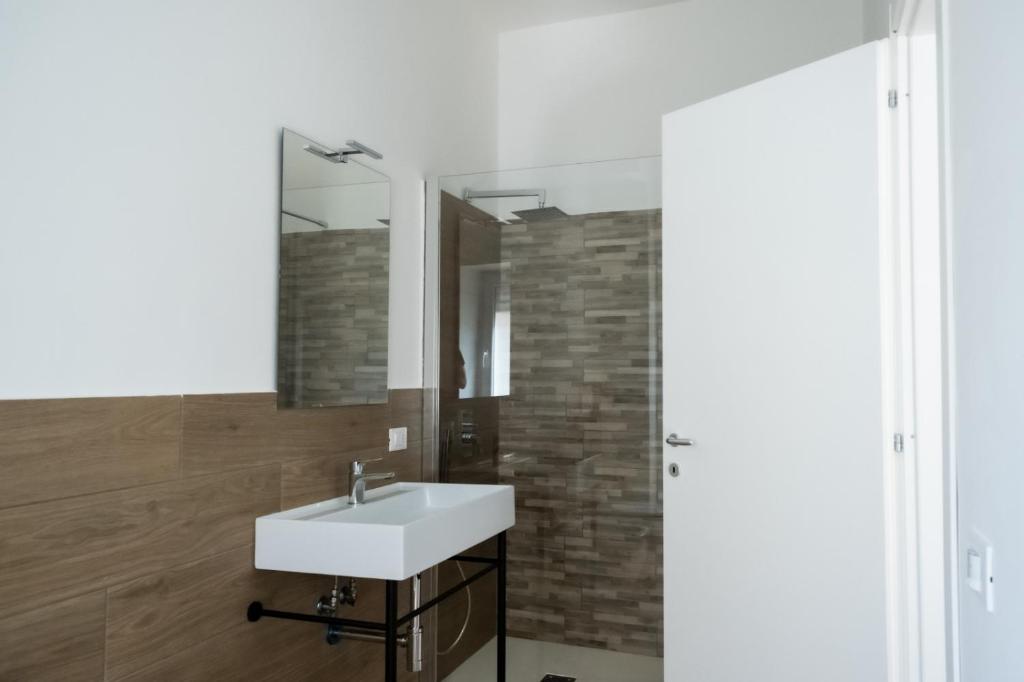 uma casa de banho com um lavatório branco e um espelho. em Home 42 B&B em Terracina
