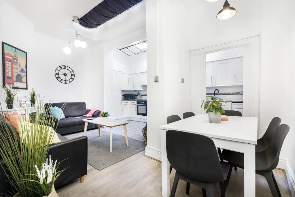 a dining room and living room with a white table and chairs at Two Bedroom Apartment in Central London with Large Terrace in London