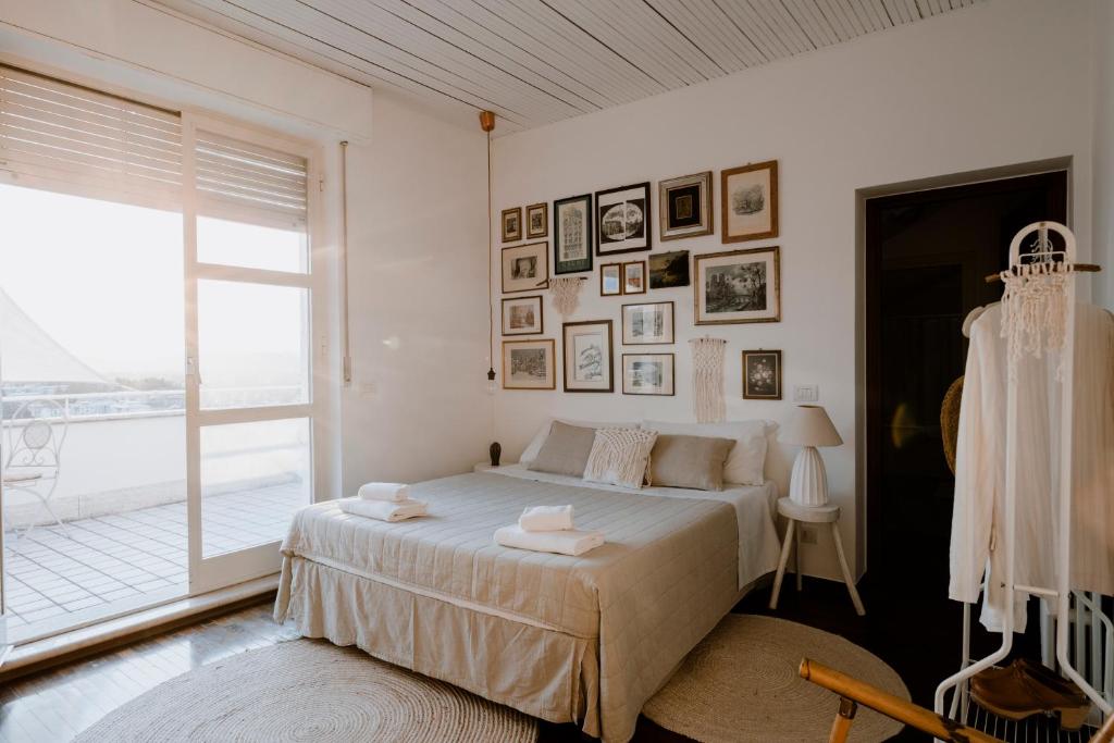 um quarto branco com uma cama e uma grande janela em "Villa Alba" stay with the Somms em Alba