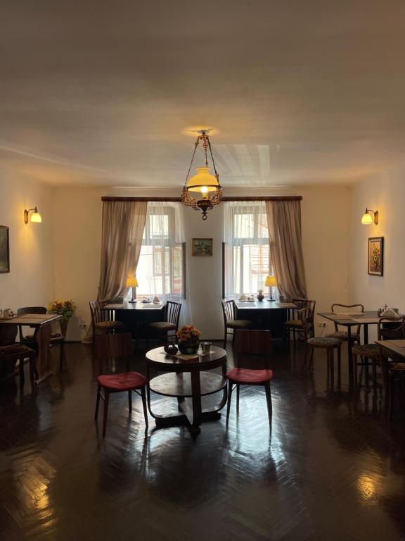 a dining room with tables and chairs and a chandelier at Pensiunea Central Sibiu in Sibiu
