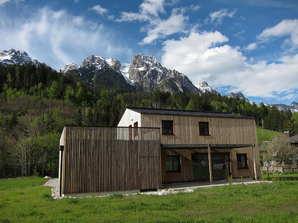 a wooden building with mountains in the background at Ferienhaus Friedle in Leogang