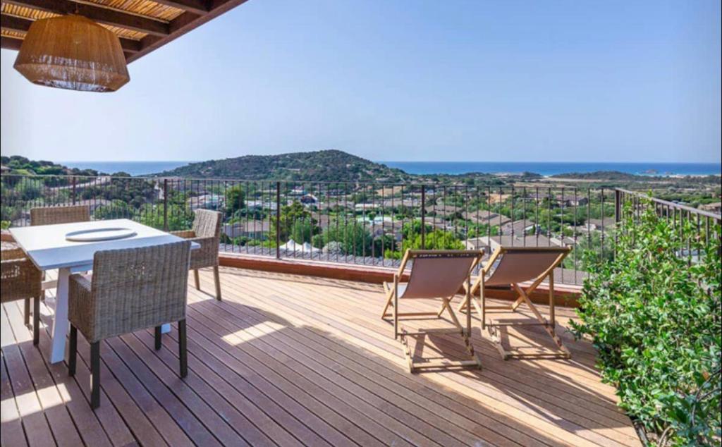 a patio with a table and chairs on a deck at Torretta con vista mozzafiato in Chia
