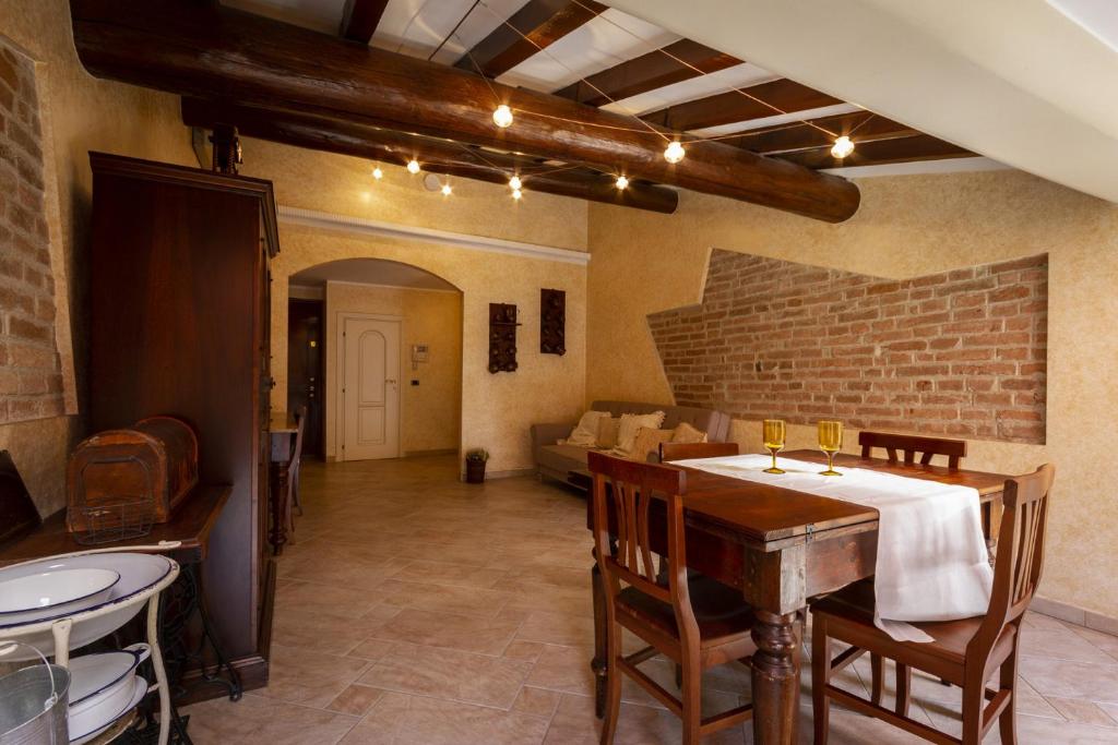 a dining room with a table and chairs and a brick wall at Grace apartment - Smart Holiday in Mantova