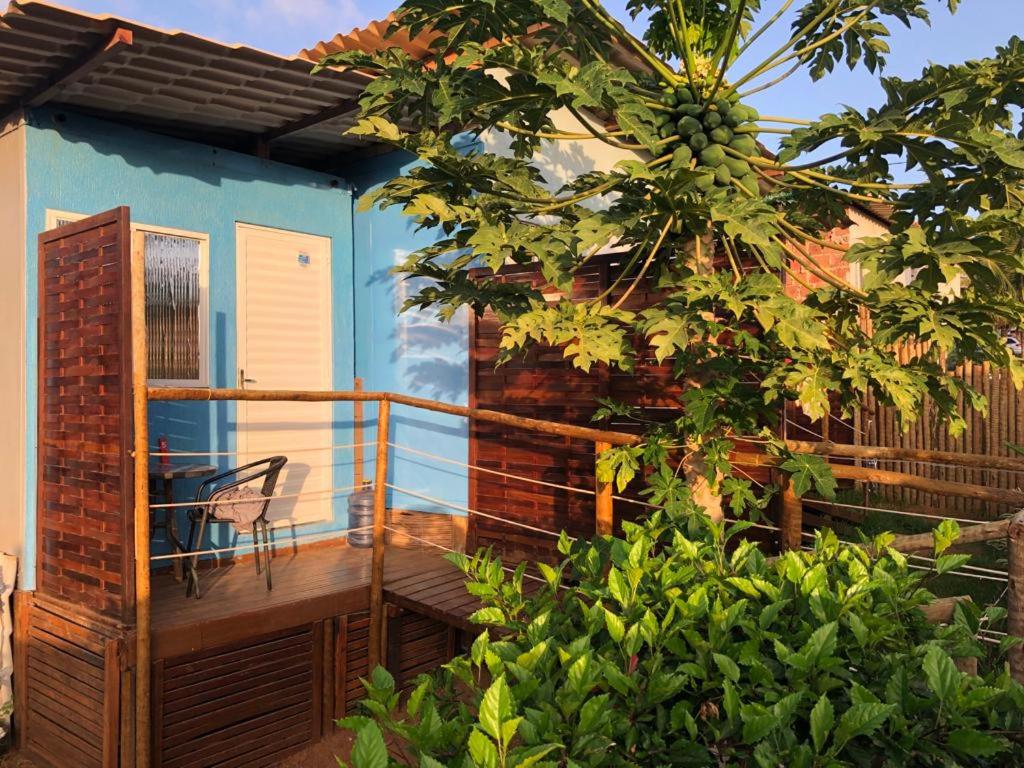 Un balcón de una casa azul con una silla. en Casinha do Cadu, en Fernando de Noronha