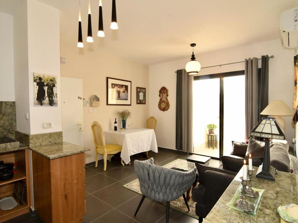 a living room with a table and a dining room at Hoffman Executive Suites - Beachfront Nahariya in Nahariyya