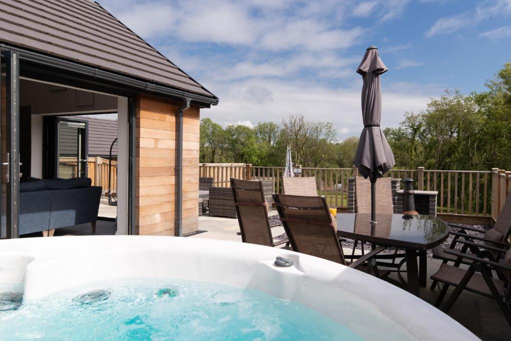 a bath tub sitting next to a patio with an umbrella at Willow Cottage in Tenby