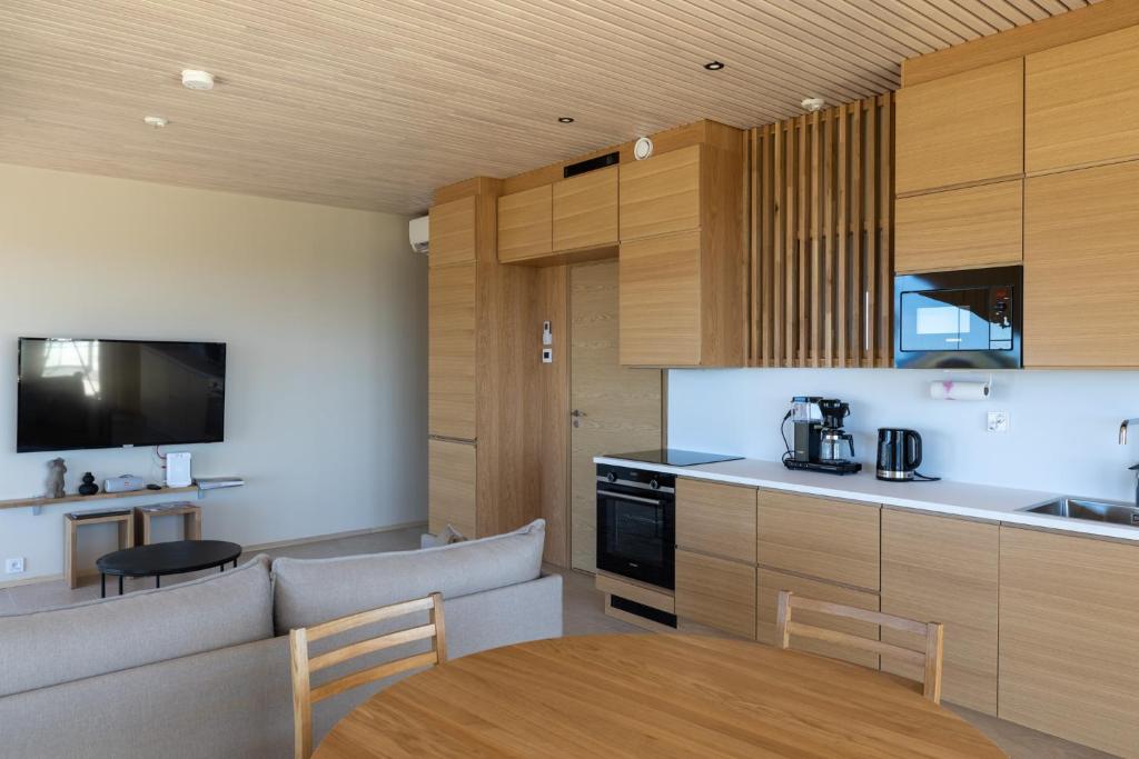 a kitchen with a table and a couch and a kitchen with a tableablish at Marina Resort A7 in Kalajoki
