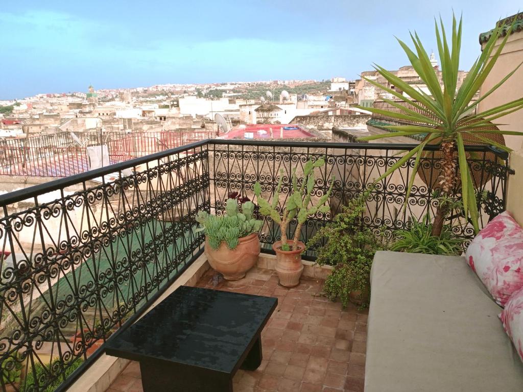 een balkon met een tafel en potplanten erop bij Dar Azahara in Fès