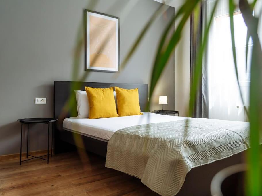 a bedroom with a bed with yellow pillows at Downtown friendly studio in Bucharest