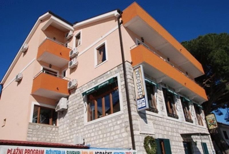 ein Gebäude in Orange und Weiß in der Unterkunft Hotel Fiammanti in Herceg-Novi