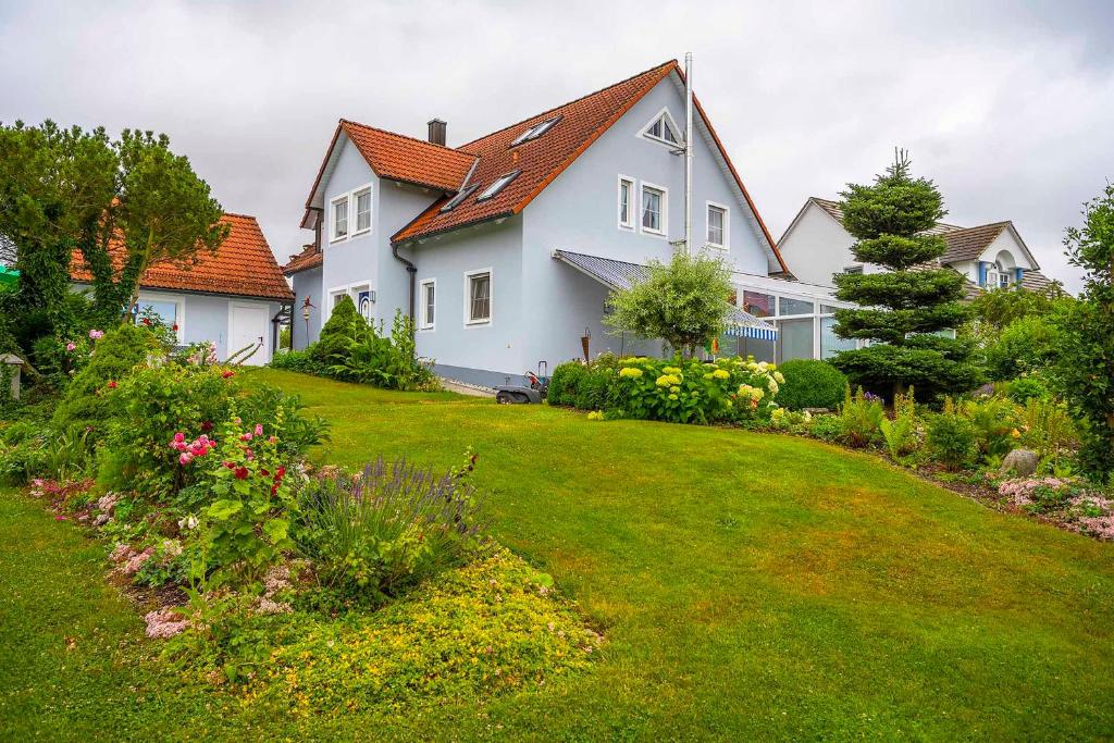 a large white house with a yard with flowers at Ferienwohnung Schötz in Moosbach