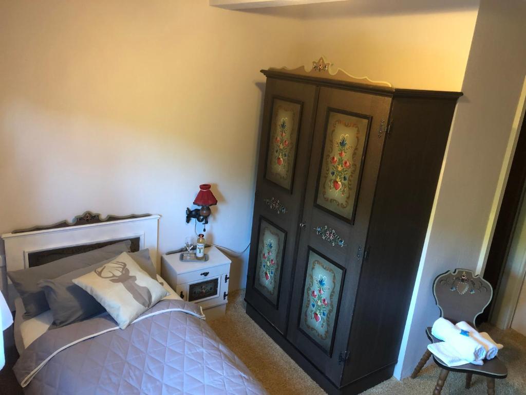 a bedroom with a bed and a cabinet with stained glass at Vesperstube Michelbach in Gaggenau