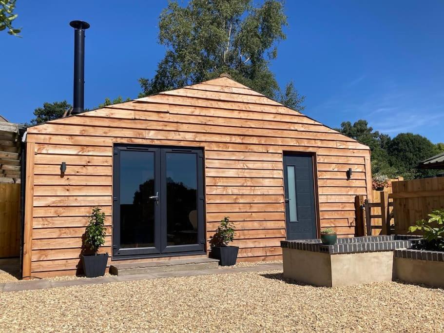 a small wooden building with plants in front of it at Liberty Lodge in Winsham