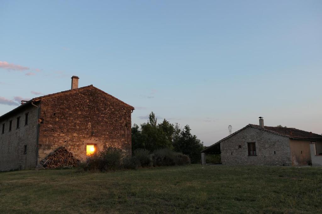 Ferme fortifiée du 18e rénovée avec vue في Lacroisille: مبنى من الطوب القديم مع ضوء في النافذة